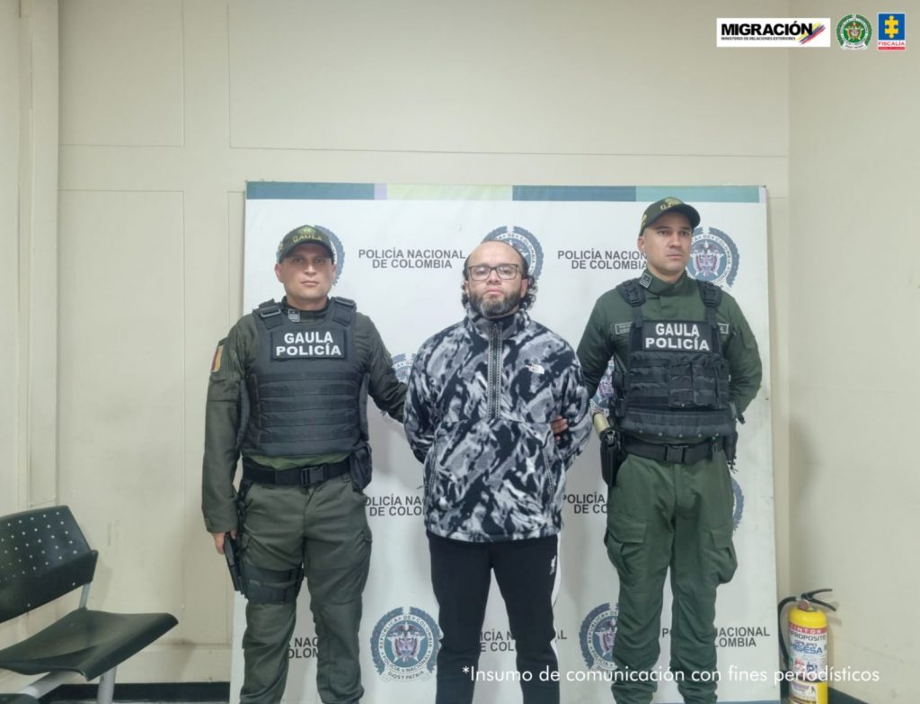 En la fotografía se encuentran tres personas dos de ellas los uniformados de la Policía nacional que se encuentran custodiando a la persona capturada