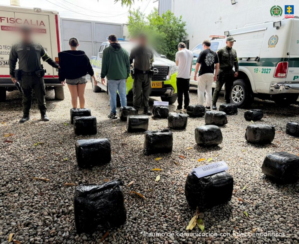 En la imagen se ven cuatro personas capturadas de espaldas, junto a tres uniformados de la Policía Nacional. Al frente se ven varios paquetes de marihuana incautados.
