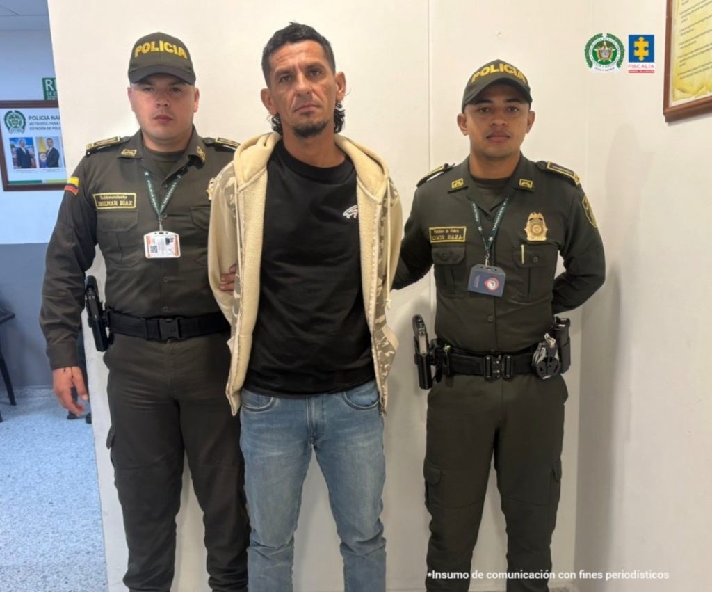 Se visualiza al capturado junto a dos uniformados de la Policía Nacional.