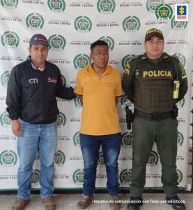 En la fotografía aparece un hombre capturado, acompañado de un servidor del (CTI), un uniformado de la Policía. En la parte posterior un banner con logos de la entidad.
