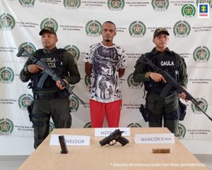 Fiscal Martha Mancera, Martha Mancera, Fiscal Mancera En la fotografía aparece un hombre capturado, acompañado de dos uniformados de La Policía. En la parte posterior un banner con logos de la entidad.