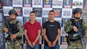 En la fotografía aparecen dos hombres capturados, acompañados de dos uniformados del Gaula del Ejército. En la parte posterior un banner con logos de la entidad.
