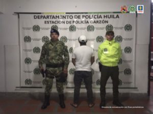 n la fotografía aparece un capturado junto a personal de Ejército Nacional y Policía Nacional. En la parte posterior de la imagen se ven banners de Ejército Nacional, Policía Nacional y la Fiscalía General de la Nación.