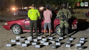 En la fotografía aparece un hombre capturado, acompañado de dos uniformados de la Policía Nacional y los elementos decomisados.