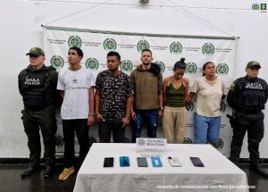 En la imagen están los 5 adultos en medio de 2 servidores del Gaula de la Policía Nacional.