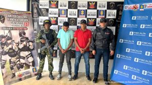 Los imputados están esposados con sus manos adelante y custodiados por uniformados de la fiscalía y el Ejército nacional.