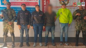 En la imagen se ve una persona detenida bajo custodia de investigadores del CTI de la Fiscalía, Ejército y Policía. Detrás suyo backings institucionales. 