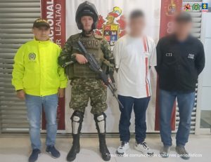 En la imagen se ve un hombre detenido bajo custodia de un integrante del CTI, Policía Nacional y el Ejército. Detrás suyo un backing institucional.
