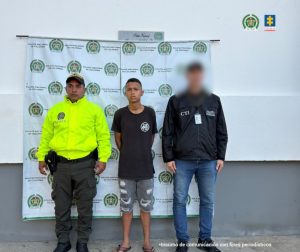 en la imagen se ve un hombre detenido bajo custodia de un investigador del CTI y otro de la Policía.