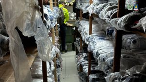 En las fotos se observan funcionarios de la Policía Nacional haciendo inspección a mercancía en el lugar en donde fueron hallados los zapatos falsificados que no contarían con documentación para su ingreso al país.