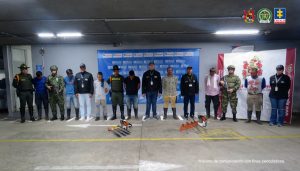 en la imagen se ven siete personas detenidas bajo custodia del CTI, Policía y Ejército. Detrás suyo varios backing institucionales y delante de ellos elementos incautados.