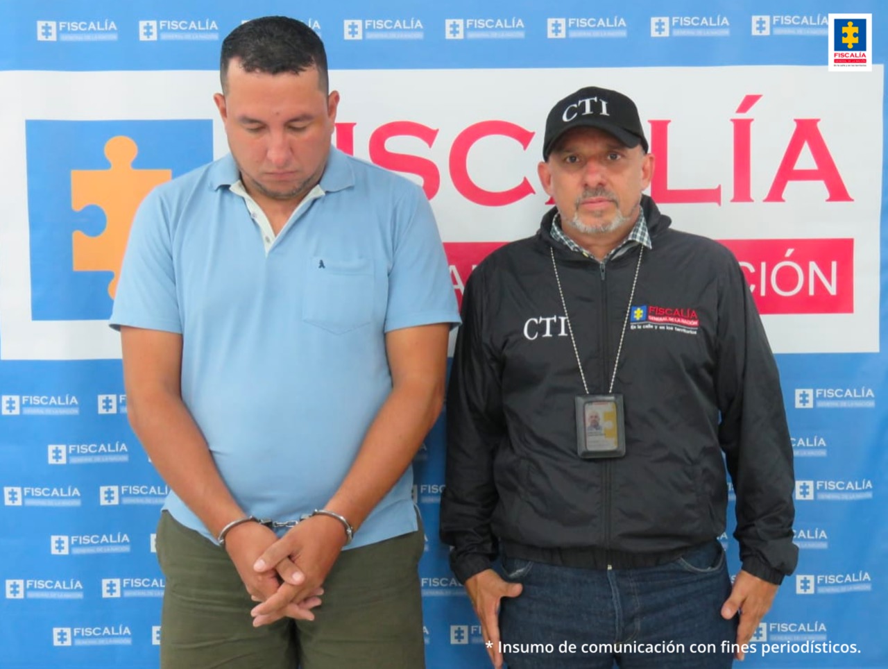 En la foto se ve un investigador del CTI de la Fiscalía con un detenido. Detrás hay un backing de la Fiscalía.