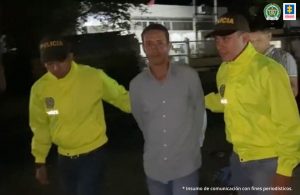 en la imagen se ve una persona detenida en custodia de dos integrantes de la Ponal.