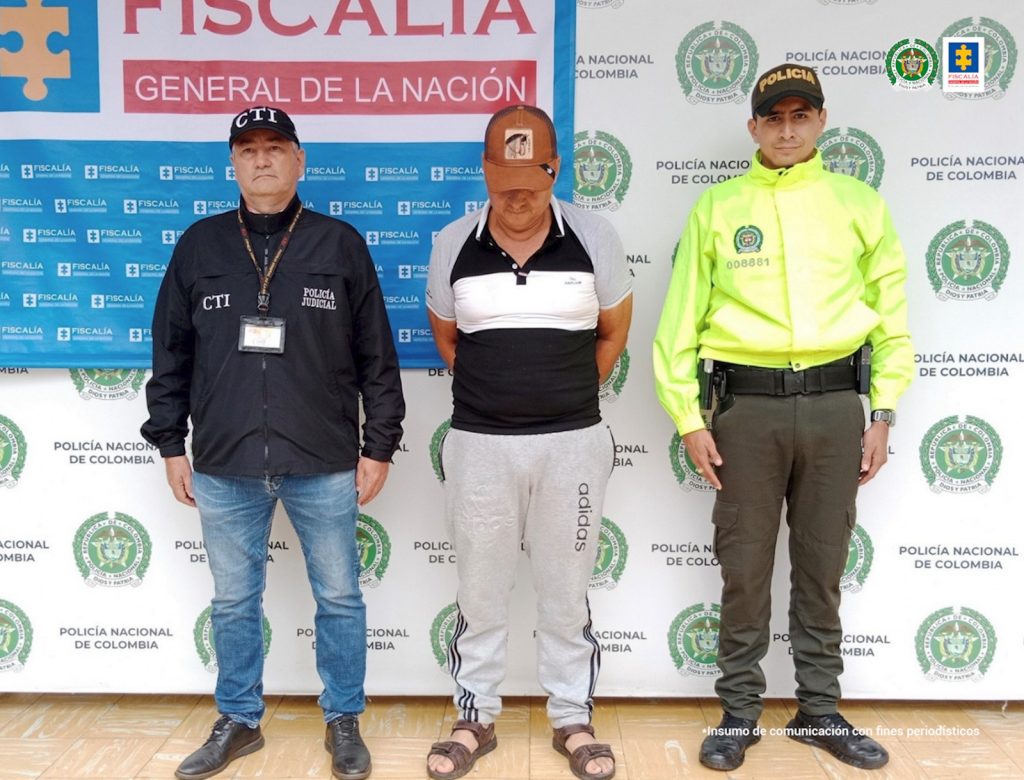 En la imagen se ve una persona detenida bajo custodia del CTI y el Ejército. Detrás suyo un backing de la Fiscalía.