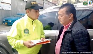 en la imagen se ve una persona a quien un uniformado de la Policía Nacional le lee sus derechos en calidad de persona detenida.