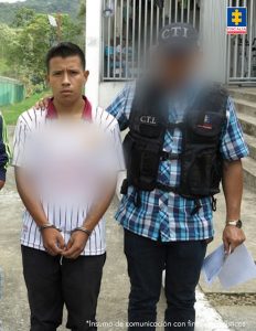 En la imagen se ve una persona detenida bajo custodia de un investigador del CTI.