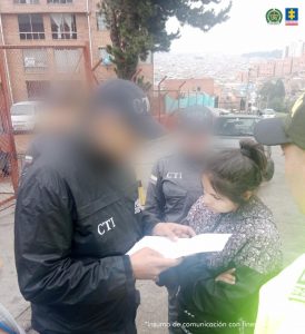El la fotografía se observan tres personas dos de ellas investigadores del CTI, y la capturada que le están leyendo sus derechos.
