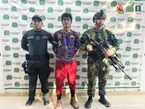 Fotos 1 Y 2 capturados de frente, custodiados por policías y militar del Ejército Nacional.