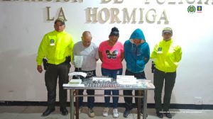 En la fotografía aparece un capturado, junto a personal de Policía Nacional. En la parte posterior de la imagen se ven banners de Policía Nacional y la Fiscalía General de la Nación.