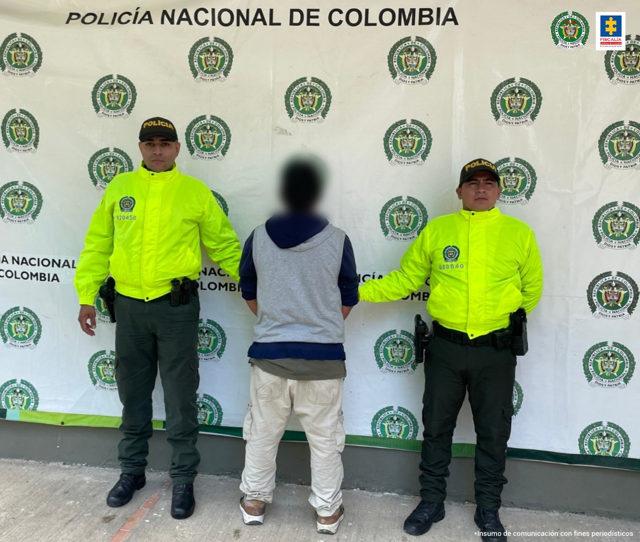 Tres personas judicializadas por delitos sexuales contra menores de edad en Tolima En la imagen se ve una persona detenida bajo custodia de la Policía. Detrás suyo un backing de la institución.