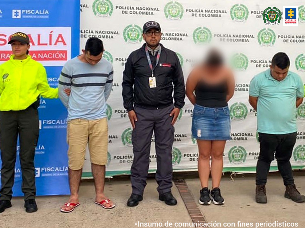En la foto se ven funcionarios del CTI de la Fiscalía y la Policía Nacional con dos personas detenidas. Detrás de ellos hay backings de la Fiscalía y la Policía.