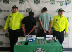 en la imagen se ven ocho personas detenidas bajo custodia de la Policía Nacional. Detrás suyo un backing institucional.