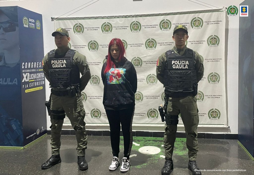 En la imagen está la procesada con dos funcionarios del Gaula de la Policía a sus lados