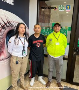En la foto está el ciudadano tailandés con un servidor de la Policía Nacional y otro de Migración Colombia