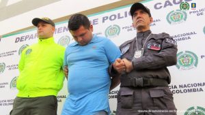 : en la imagen una persona detenida en custodia del CTI y la Policía. Detrás suyo un backing de esta última institución.