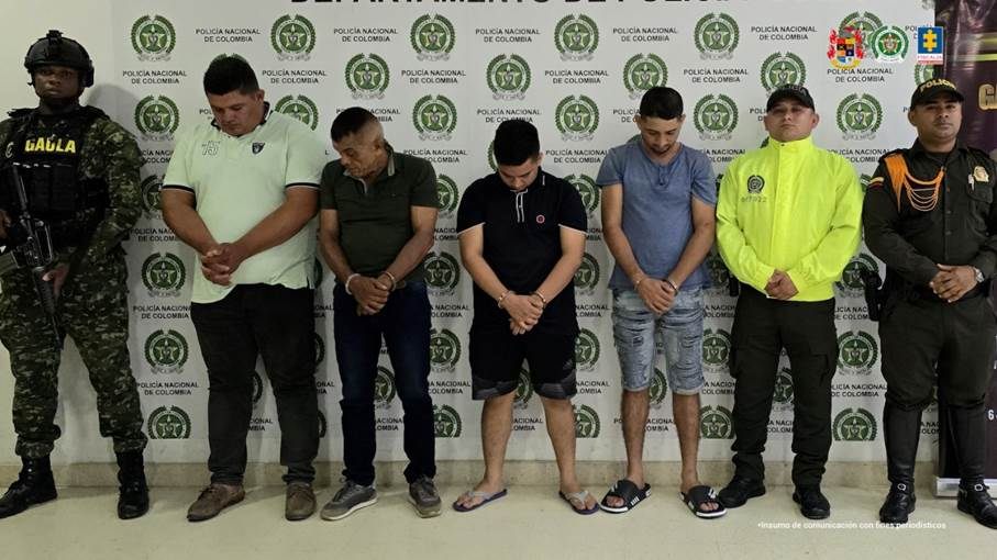 Se visualiza a los capturados junto a uniformados del Ejército y Policía Nacional. Detrás de ellos el banner que identifica a la Policía Nacional.