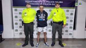 en la imagen se ve una persona detenida bajo custodia de dos uniformados de la Policía Nacional.