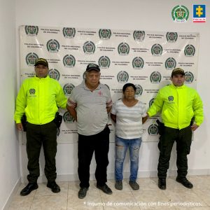 en la imagen se ven dos personas detenidas bajo custodia de la Policía Nacional. Detrás suyo un backing institucional.