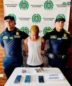 En la imagen un hombre detenido bajo custodia de dos integrantes de la Policía Nacional.