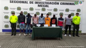 En la foto aparecen de pie los presuntos integrantes de ‘Los AK-47’o ‘Los Del Platanal’. Al lado y lado de ellos hay uniformados de la Policía Nacional. Detrás de ellos hay un pendón institucional de la Policía.