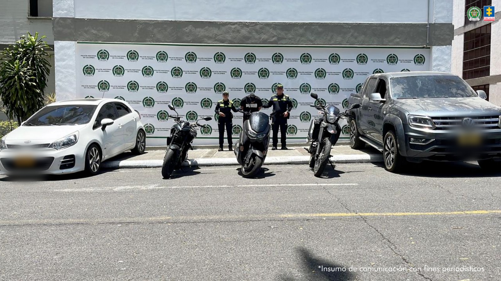 En la imagen se ve una persona detenida bajo custodia de dos uniformados de la Policía Nacional, con dos vehículos y tres motocicletas incautadas. 
