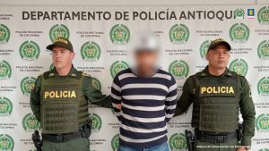 En la imagen se ve a un hombre junto a dos uniformados de la Policía, quien fue capturado en flagrancia en una vivienda donde ocurrieron hechos de violencia.