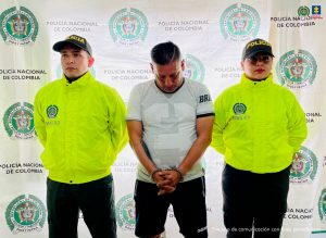 En la foto se ve al detenido Jesús Alonso Rosas acompañado de dos uniformados de la Policía y un baking de la institución.