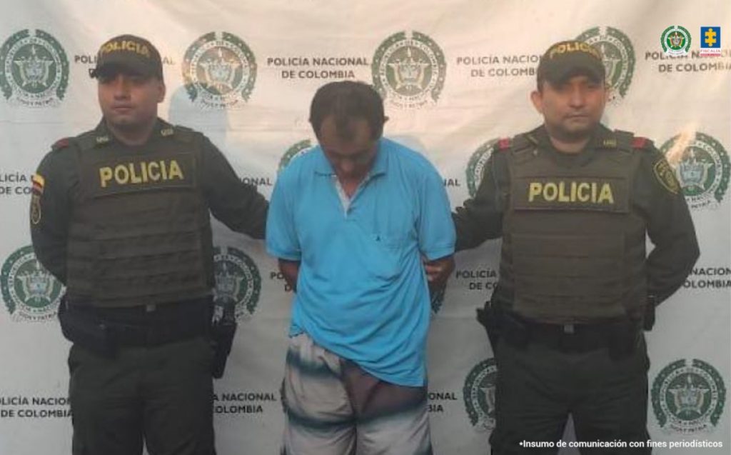 En la imagen se ve una persona detenida bajo custodia de dos uniformados de la Policía Nacional.