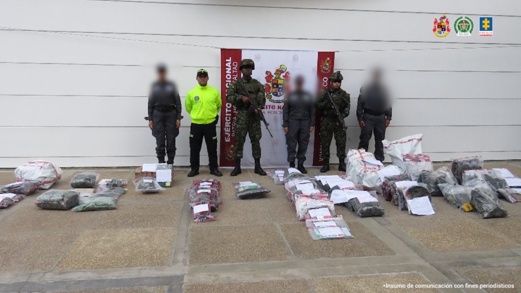 En la fotografía se puede observar a 6 funcionarios de la Policía y el Ejercito Nacional formados, en frente de ellos esta todo el material incautado