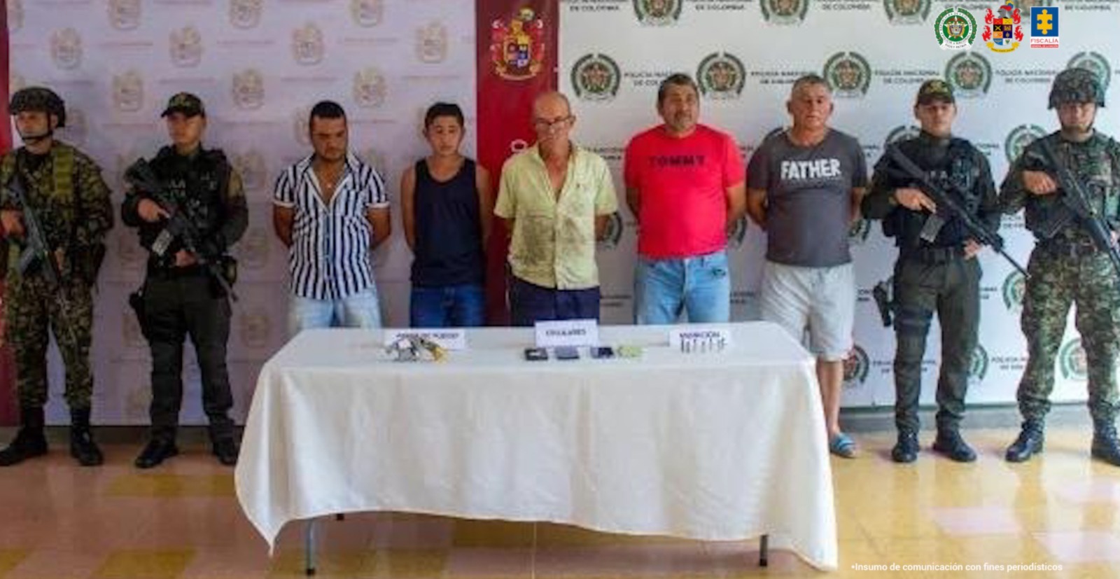 en la imagen se ven varias personas detenidas bajo custodia de integrantes del Ejército y la Policía Nacional. Detrás suyo un backing institucional.