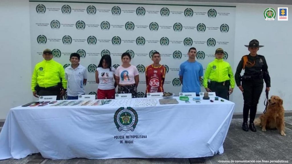 En la imagen se ven cinco personas detenidas bajo custodia de servidores de la Policía Nacional.