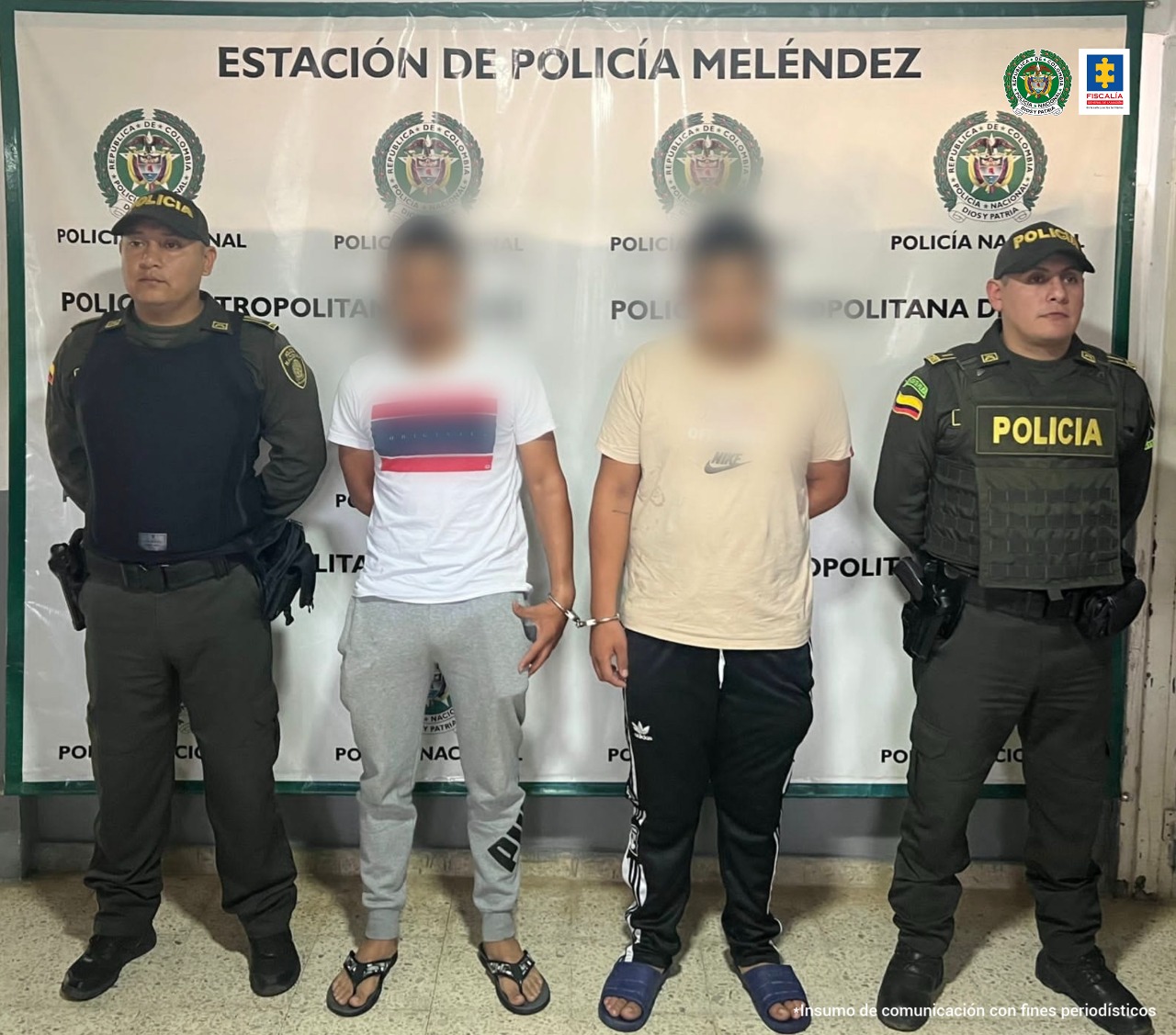 En la foto aparecen los dos asegurados junto a dos agentes de la Policía Metropolitana de Cali. En la parte posterior se ve un banner de la Policia Nacional