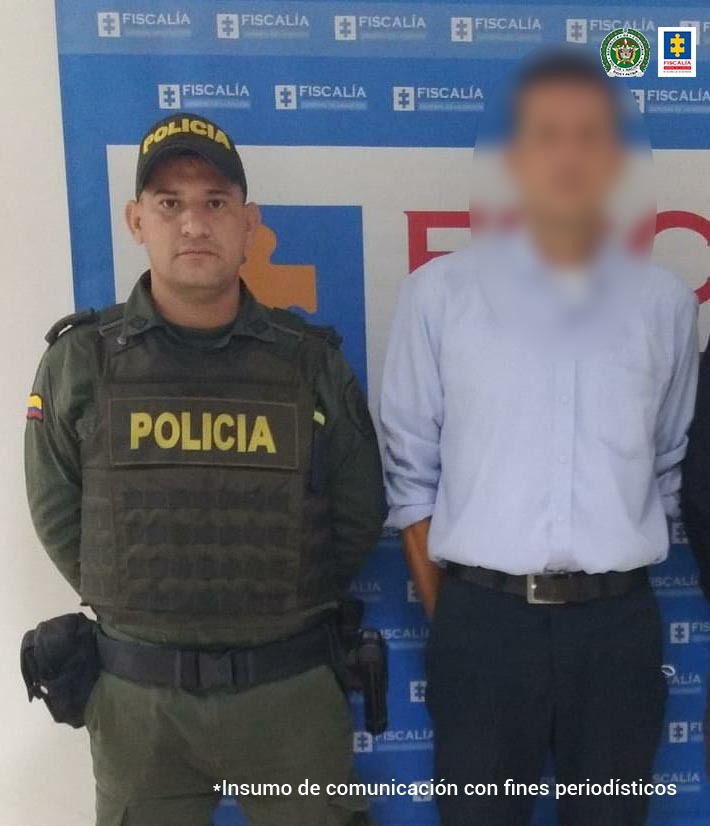 Se puede apreciar en la foto un funcionario del CTI y un miembro de la Policía Nacional custodiando al hoy asegurado, quien tiene la cara distorsionada.