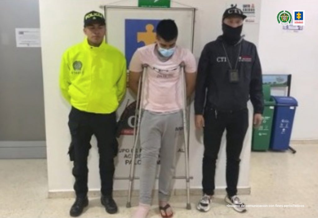 en la imagen se ve una persona detenida bajo custodia de un investigador del CTI y un integrante de la Policía Nacional.