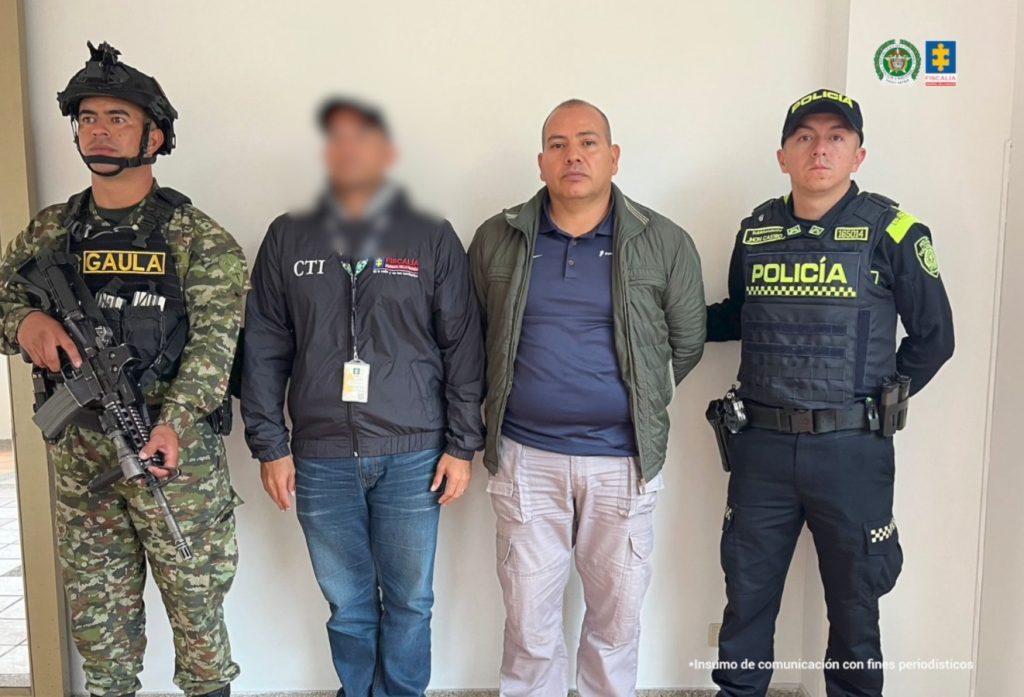 en la imagen un hombre detenido bajo custodia de un investigador del CTI y funcionarios del Gaula Militar y la Policía Nacional.