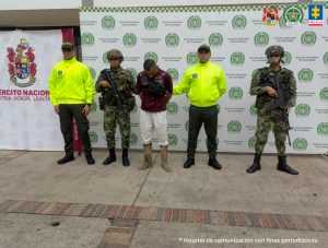  En la imagen se ve una persona detenida bajo custodia de integrantes de la Policía Nacional y el Ejército.
