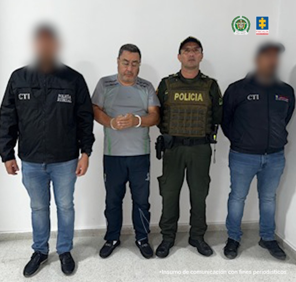 En la imagen se ve una persona detenida bajo custodia de dos integrantes del CTI y uno de la Policía.