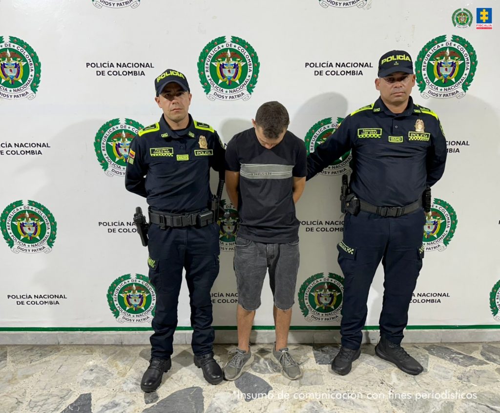 en la imagen se ve un hombre detenido bajo custodia de las autoridades.