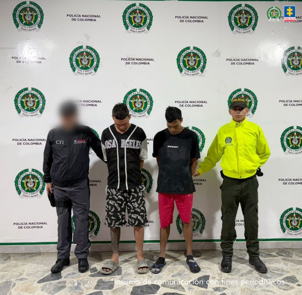 en la imagen se ven dos personas detenidas bajo custodia de investigadores del CTI y la Policía. Detrás suyo un backing institucional.