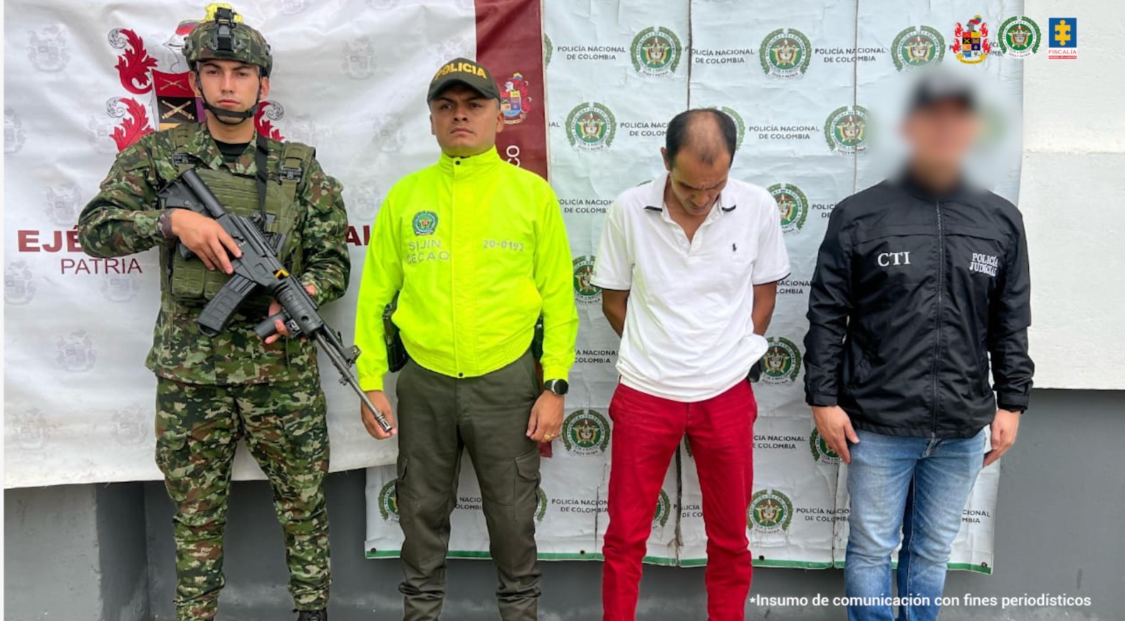 En la imagen se ve una persona detenida bajo custodia del CTI, Ejército, y Policía. Detrás suyo un backing institucional.